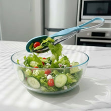 Load image into Gallery viewer, Glass bowl with salad being scooped by a blue salad spinner in a kitchen setting