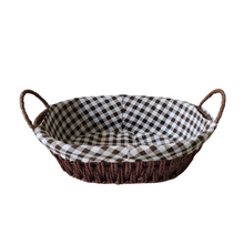 Load image into Gallery viewer, Oval bread proofing basket made of natural rattan with a checkered brown and white linen liner, featuring handles on the sides.