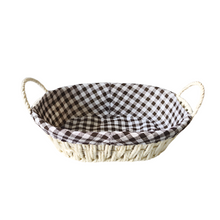 تحميل الصورة في عارض المعرض، Oval bread proofing basket made of natural rattan with a checkered brown and white linen liner, featuring handles on the sides.