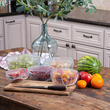 Load image into Gallery viewer, Plastic food storage covers protect fruit bowls on a wooden table in a kitchen setting.