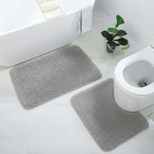 Load image into Gallery viewer, Gray bath mats on a bathroom floor with a toilet and plant in the background.