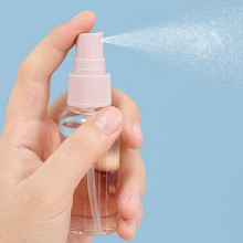 Load image into Gallery viewer, Hand holding a spray bottle, demonstrating a fine mist spray for travel toiletries.
