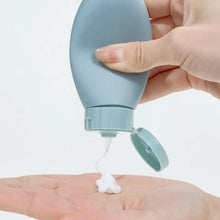 Load image into Gallery viewer, A hand squeezes a light blue squeeze bottle to dispense white lotion onto another hand, set against a clean white background.
