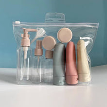 Load image into Gallery viewer, Set of cosmetic bottles in pastel colors in a clear plastic bag against a blue background
