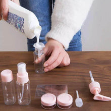 Load image into Gallery viewer, Person pouring liquid into a small bottle with various small containers and bottles on a wooden surface.