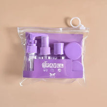 Load image into Gallery viewer, Purple travel bottle set with clear packaging on a beige background