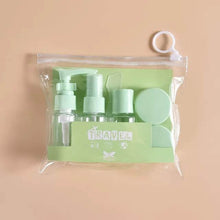 Load image into Gallery viewer, Set of green travel-sized bottles and accessories in a clear pouch on a beige background