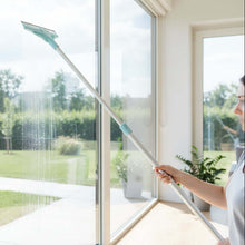 Load image into Gallery viewer, Person cleaning a window with a squeegee in a bright room with large windows.