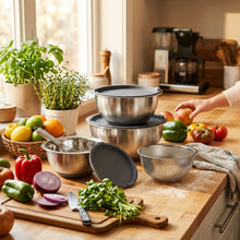 Load image into Gallery viewer, A set of stainless steel kitchen bowls and a strainer with dark gray silicone lids, arranged on a clean white background.
