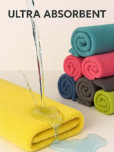 Load image into Gallery viewer, Yellow towel absorbing water with rolled towels in the background and text 'ULTRA ABSORBENT'.