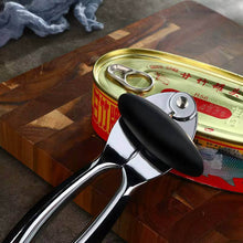 Load image into Gallery viewer, Heavy-duty stainless steel can opener with ergonomic handle beside a can on a wooden cutting board.
