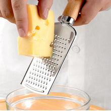 Load image into Gallery viewer, Stainless steel cheese grater in use, grating a block of cheese above a glass bowl.