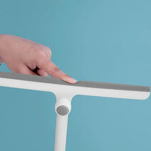 Load image into Gallery viewer, Hand using the 360° rotating head of the squeegee on a blue background for efficient cleaning.