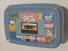 Load image into Gallery viewer, A light blue plastic lunch box featuring a colorful retro 90s graphic design on the front, complete with a cassette tape illustration and text like '90's Party' and '90's Super Hits'.