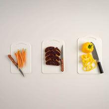 تحميل الصورة في عارض المعرض، Three cutting boards with sliced vegetables and knives on a light gray background