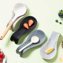 Load image into Gallery viewer, Set of black, gray, and white ceramic spoons with wooden handles on a light green background.
