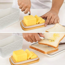 Load image into Gallery viewer, Person spreading butter from a porcelain dish onto a slice of bread using a stainless steel spreader.
