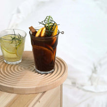 Load image into Gallery viewer, Two glasses of iced drinks with garnishes on a wooden coaster.
