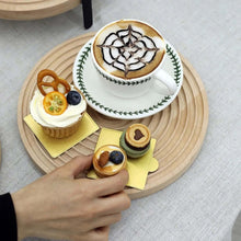 Load image into Gallery viewer, Cup of coffee with decorative art, cupcake, and small pastries on a wooden tray.
