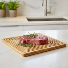 Load image into Gallery viewer, Raw steak on a wooden cutting board with herbs in a kitchen setting
