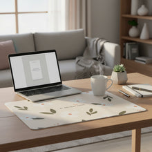 Load image into Gallery viewer, A rectangular desk mat with a floral pattern of white flowers and green leaves on a beige background, featuring the text 'BE AWESOME TOUCH' in the center, placed on a wooden desk.
