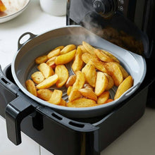 تحميل الصورة في عارض المعرض، Air fryer basket with golden-brown fries on a kitchen counter.
