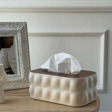 Load image into Gallery viewer, White textured tissue box on a wooden surface with a decorative frame in the background.
