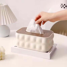 Load image into Gallery viewer, Person taking a tissue from a modern tissue box on a table.
