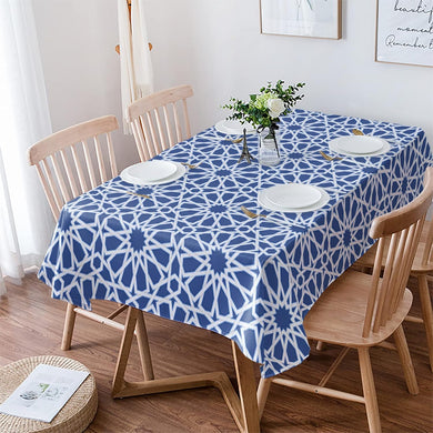 Dining table with a blue geometric patterned tablecloth, surrounded by wooden chairs.