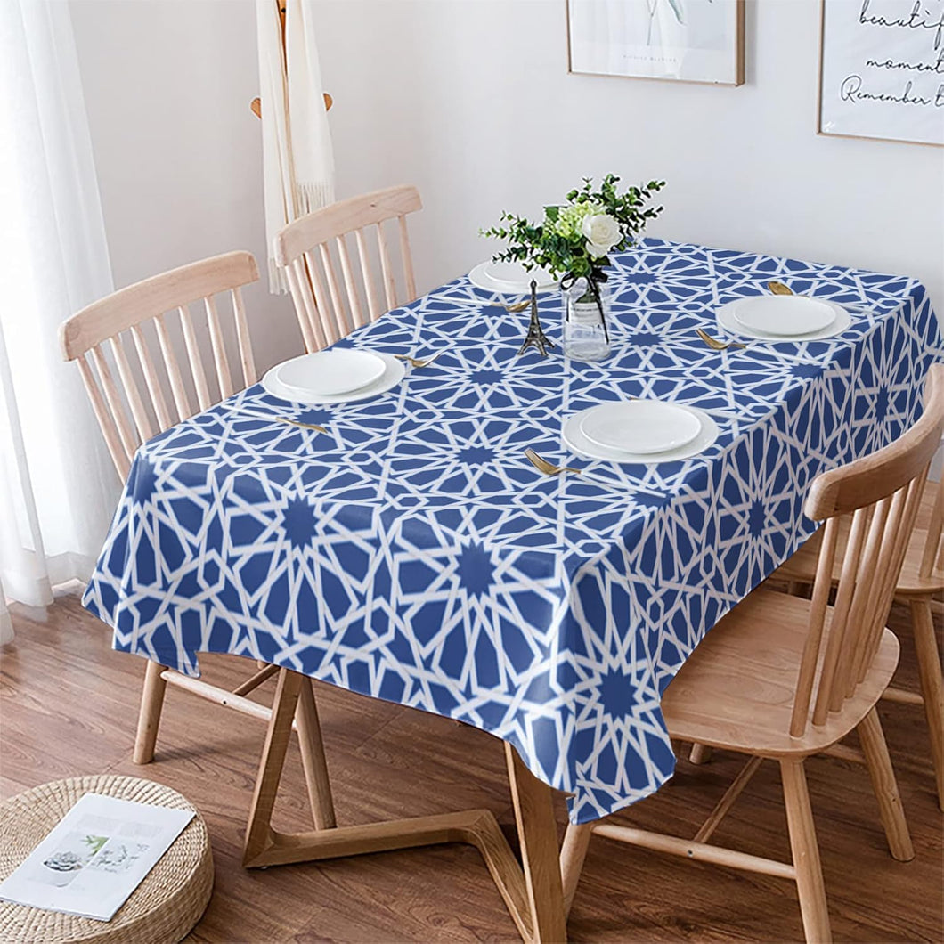 Dining table with a blue geometric patterned tablecloth, surrounded by wooden chairs.