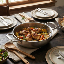 تحميل الصورة في عارض المعرض، Cooked chicken dish with vegetables in a pan on a table set for dinner.
