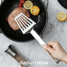 تحميل الصورة في عارض المعرض، Hand holding a white spatula over a pan with a hamburger and vegetables, on a light gray surface with 'dapurnesia' branding.
