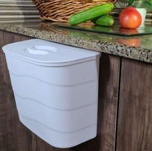تحميل الصورة في عارض المعرض، White wall-mounted trash can on a wooden cabinet with a kitchen counter in the background.
