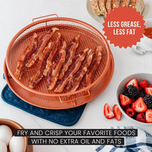 تحميل الصورة في عارض المعرض، Bacon being cooked in a copper-colored fryer basket with a bowl of berries and eggs on a white surface.
