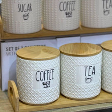 Load image into Gallery viewer, Set of white ceramic storage jars with wooden lids labeled &#39;Coffee&#39; and &#39;Tea&#39; on a wooden tray.
