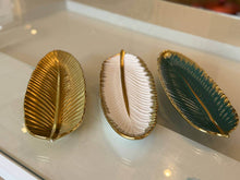 تحميل الصورة في عارض المعرض، Three leaf-shaped decorative items in gold, silver, and green on a reflective surface.
