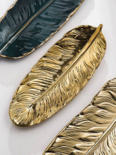 تحميل الصورة في عارض المعرض، Gold leaf-shaped decorative items on a light background
