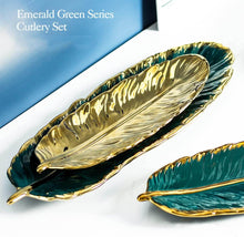 تحميل الصورة في عارض المعرض، Gold and green leaf-shaped cutlery set on a white surface with a blue background.
