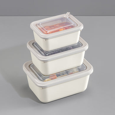 Set of three stacked food storage containers with lids on a gray background