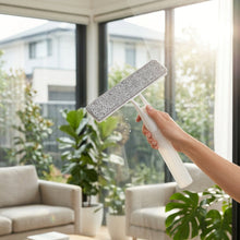 Load image into Gallery viewer, A white plastic T-bar style floor scrubber with a gray microfiber pad, resting on a white textured fabric surface.
