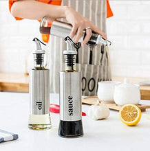 تحميل الصورة في عارض المعرض، Stainless steel oil and vinegar dispenser set with food-grade glass bottles on kitchen counter.
