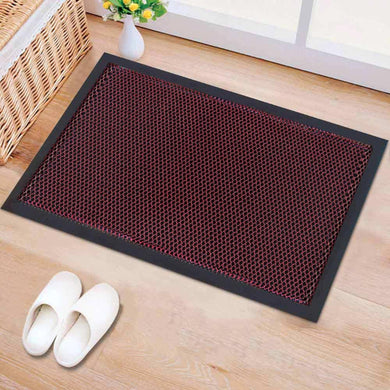 Doormat with honeycomb pattern on a wooden floor with white slippers and a basket.