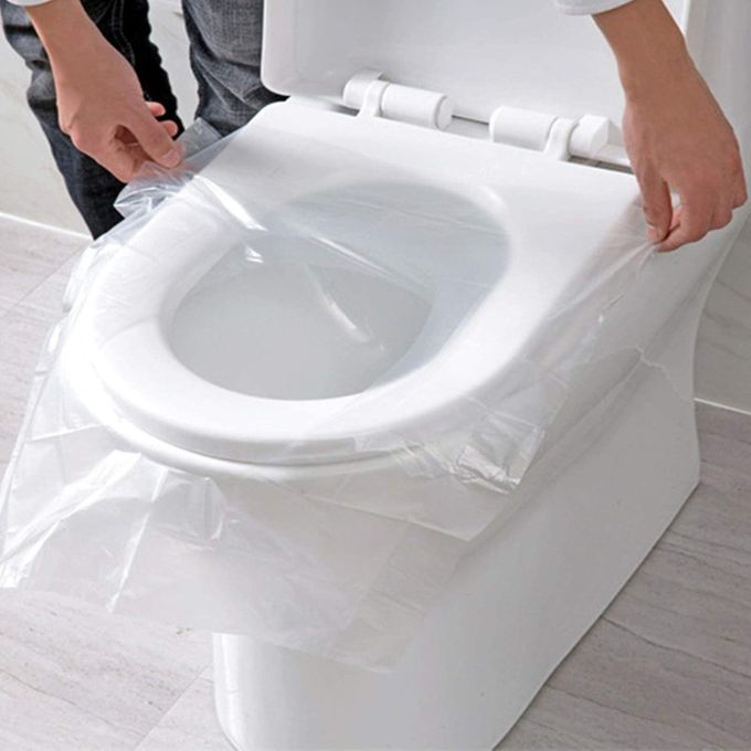 Person using a clear plastic bag to cover a toilet seat.