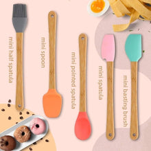 تحميل الصورة في عارض المعرض، Set of mini spatulas with wooden handles and colorful silicone heads on a pink background with food items.
