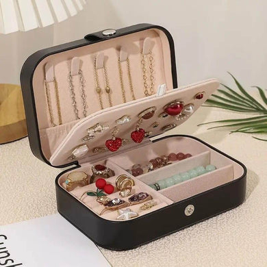 Leather portable travel jewelry box with multiple compartments for earrings, necklaces, and rings, neatly organized.