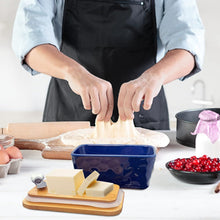 Load image into Gallery viewer, Dish Butter in a kitchen setting, featuring a porcelain butter dish with wooden lid and spreader, perfect for butter lovers.
