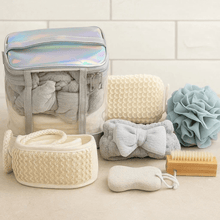Load image into Gallery viewer, Collection of bath products including a clear bag with towels, washcloths, and bath accessories on a tiled bathroom floor.
