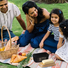 Load image into Gallery viewer, Family enjoying a picnic with a black porcelain butter dish, butter spreader, and freshly baked bread.
