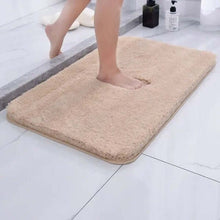 تحميل الصورة في عارض المعرض، Beige bath mat on a bathroom floor with a person stepping onto it.
