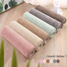 تحميل الصورة في عارض المعرض، Set of colorful bath mats on a wooden floor with a plant in the corner.
